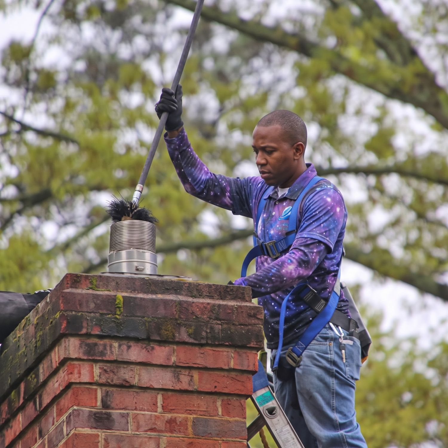Space technician sweeping a chimney from the roof